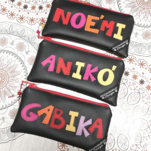Neves textilbőr tolltartó neszeszer női név szines betűk fekete alap piros cipzár